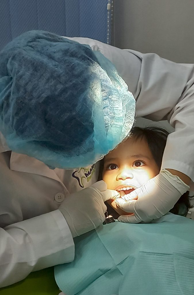 Dentist treating a young patient at Dr. Maria’s Dentistry